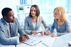 Picture of people around a table in conversation